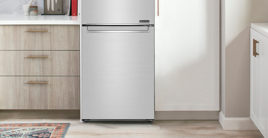 photo of bottom freezer refrigerator in a kitchen with light wood cabinets